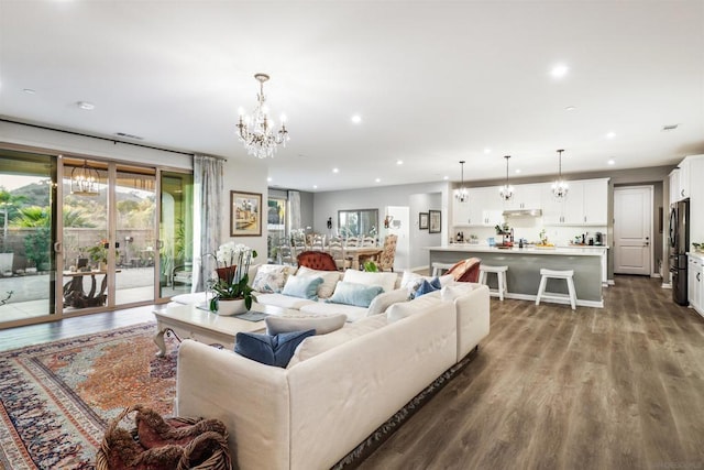 living room featuring french doors, a chandelier, and light wood-type flooring