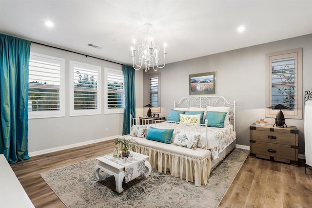 bedroom with a chandelier and hardwood / wood-style floors