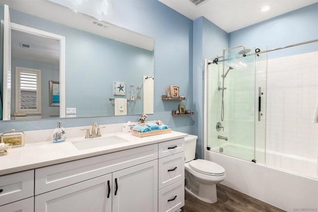 full bathroom with bath / shower combo with glass door, wood-type flooring, vanity, and toilet