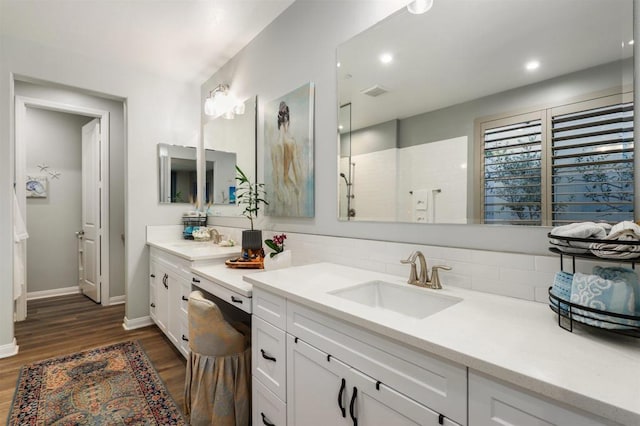 bathroom with wood-type flooring, a shower, backsplash, and vanity