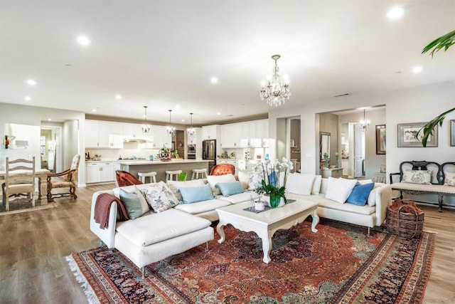 living room with an inviting chandelier and light hardwood / wood-style flooring