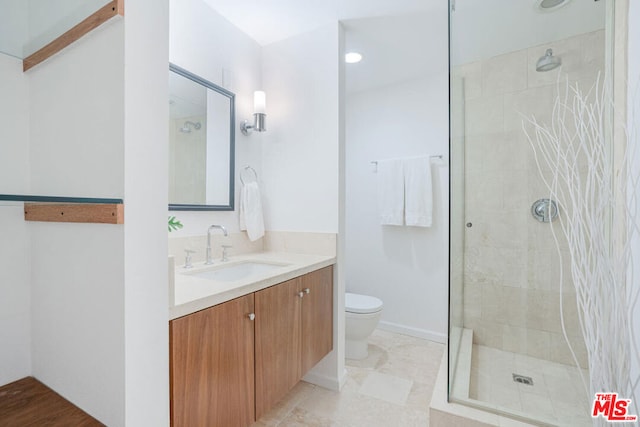 bathroom with vanity, toilet, and a tile shower