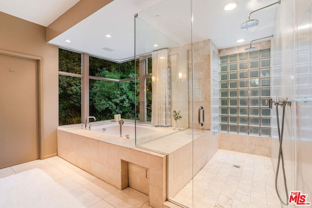 bathroom with independent shower and bath and tile patterned flooring