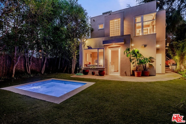 rear view of house with a lawn and a patio