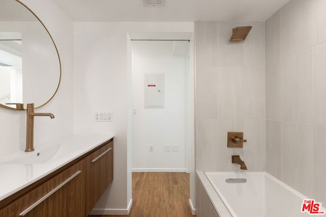 bathroom featuring vanity, wood-type flooring, and shower / tub combination