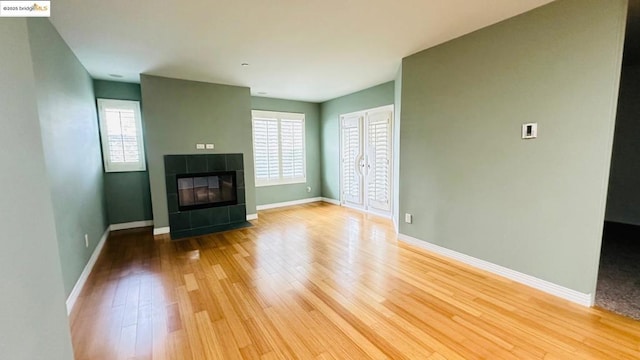 unfurnished living room with a wealth of natural light, a fireplace, and light hardwood / wood-style flooring