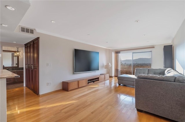 living room with crown molding and light hardwood / wood-style flooring