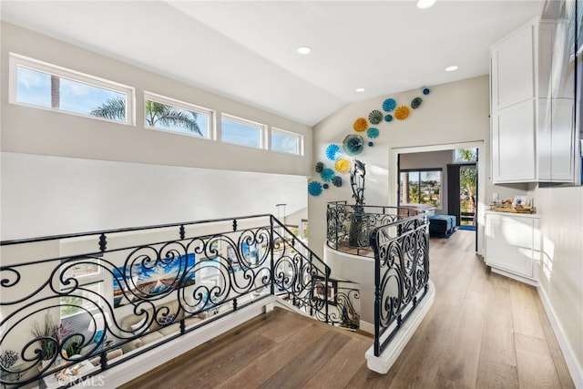 stairs featuring lofted ceiling and hardwood / wood-style floors