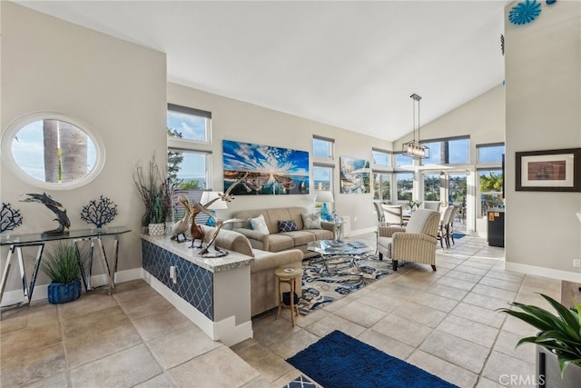 living room featuring an inviting chandelier, light tile patterned floors, plenty of natural light, and high vaulted ceiling