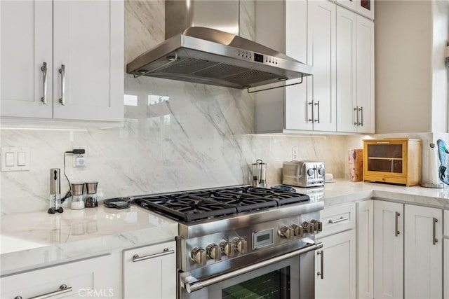 kitchen featuring white cabinetry, extractor fan, stainless steel stove, and backsplash