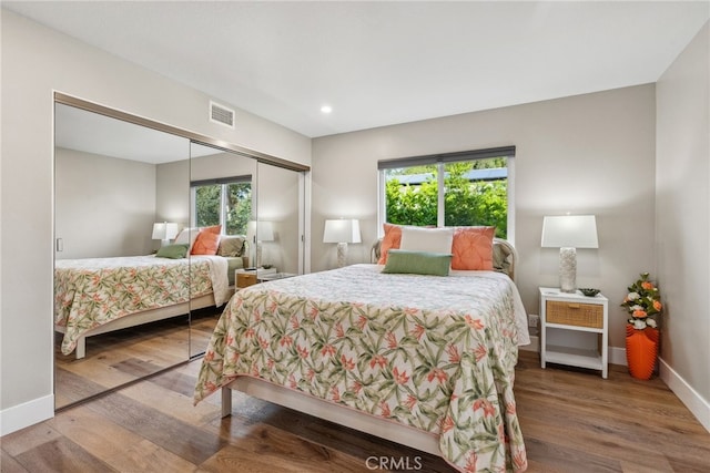 bedroom with wood-type flooring and a closet