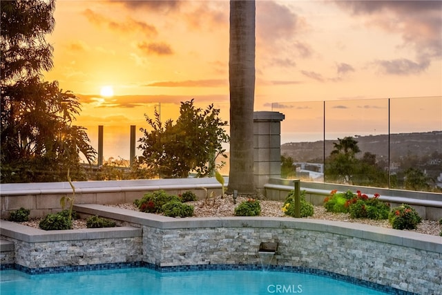 view of pool at dusk