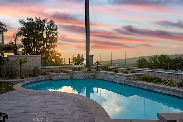 pool at dusk with a patio