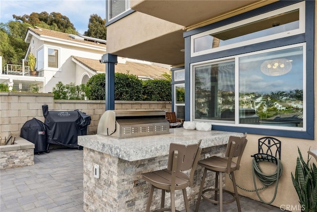 view of patio featuring area for grilling, grilling area, and an outdoor bar