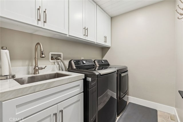 laundry area featuring cabinets, washing machine and clothes dryer, and sink