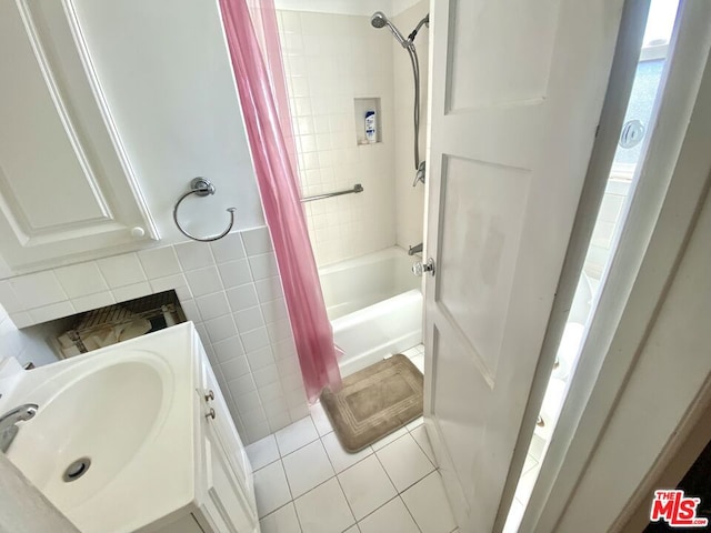 bathroom with tile patterned flooring, vanity, tile walls, and shower / tub combo with curtain