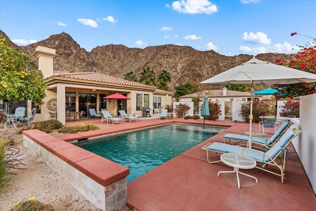 view of pool featuring a mountain view and a patio area