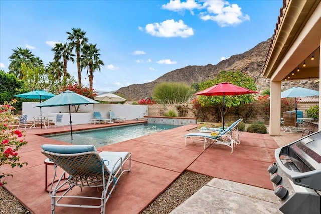 view of swimming pool featuring a patio, a mountain view, and area for grilling