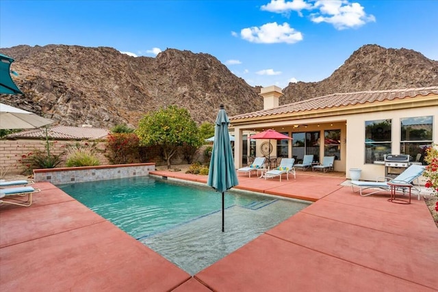 view of swimming pool with a mountain view and a patio