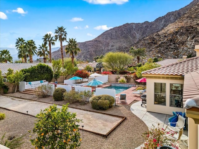 view of swimming pool with a mountain view and a patio area