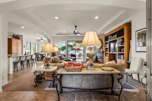 living room featuring ceiling fan and a fireplace