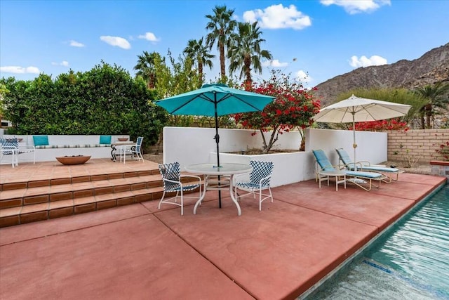 view of patio / terrace featuring a fenced in pool and a mountain view