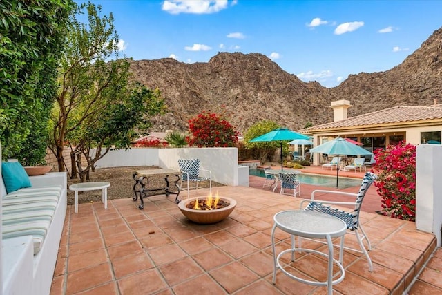 view of patio featuring a mountain view and an outdoor fire pit