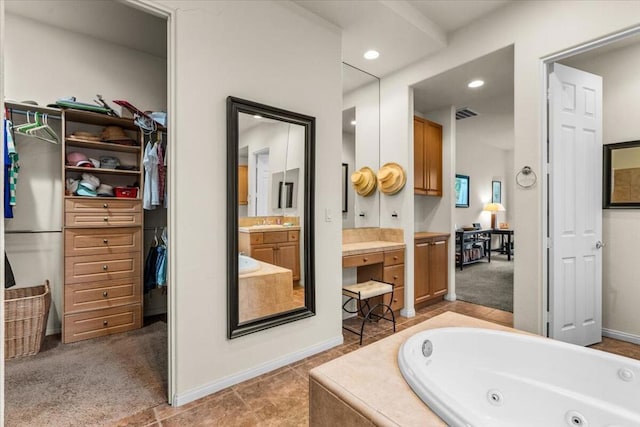 bathroom featuring vanity and a relaxing tiled tub