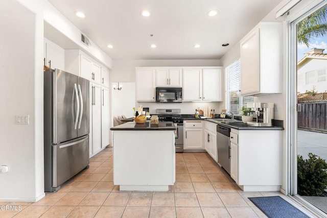 kitchen featuring light tile patterned flooring, sink, a center island, stainless steel appliances, and white cabinets