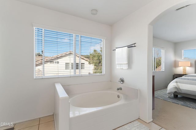 bathroom with tile patterned flooring and a tub