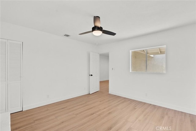 empty room with ceiling fan and light hardwood / wood-style floors