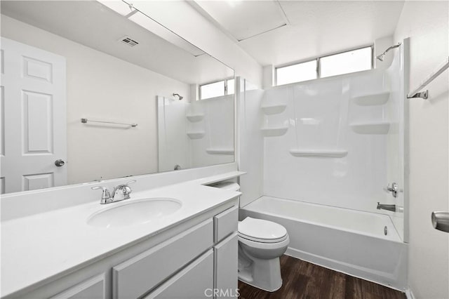 full bathroom featuring vanity, hardwood / wood-style floors, shower / bathtub combination, and toilet