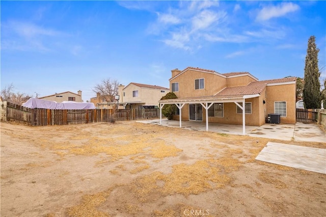 rear view of property with central AC unit and a patio area