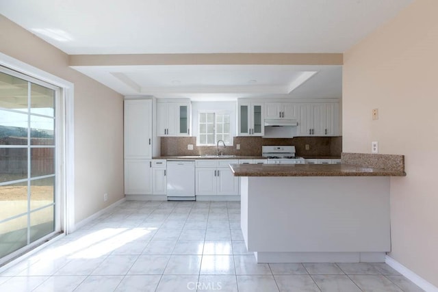 kitchen featuring white cabinetry, white appliances, a tray ceiling, and kitchen peninsula