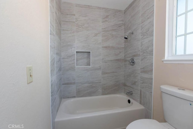 bathroom with tiled shower / bath and toilet