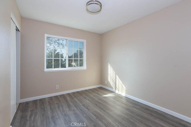 empty room with dark wood-type flooring