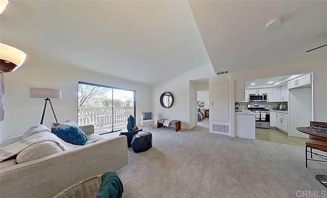 carpeted living room with high vaulted ceiling