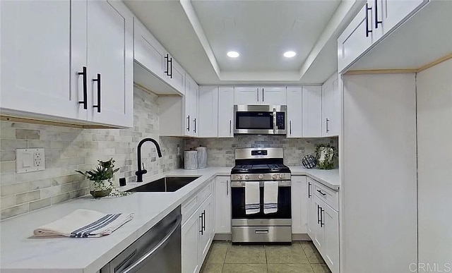 kitchen with white cabinetry, sink, backsplash, and stainless steel appliances