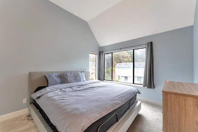 bedroom with vaulted ceiling and light colored carpet