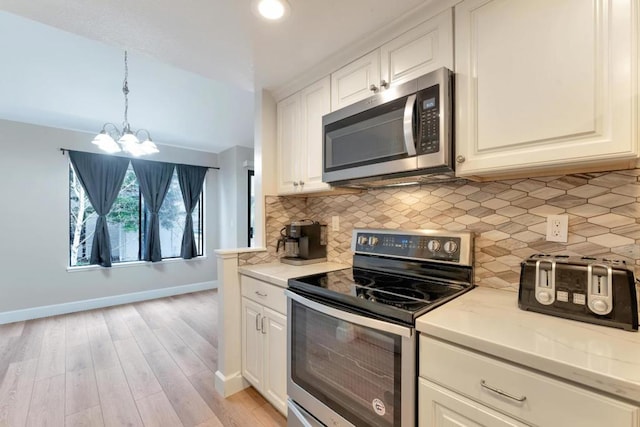 kitchen featuring hanging light fixtures, light wood-type flooring, stainless steel appliances, decorative backsplash, and white cabinets