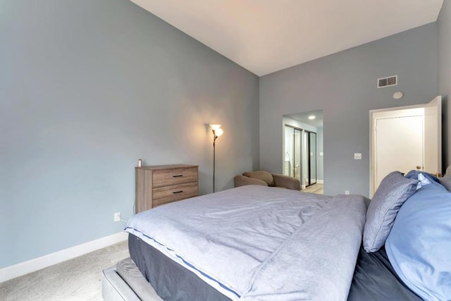 bedroom with light carpet, lofted ceiling, and a closet