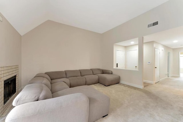 carpeted living room featuring a fireplace and vaulted ceiling