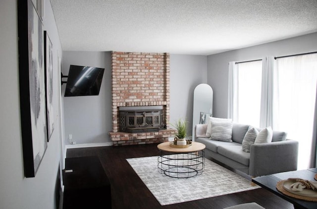 living room featuring dark hardwood / wood-style flooring, a textured ceiling, and a fireplace