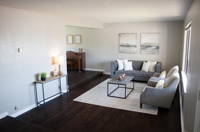 living room with dark hardwood / wood-style floors and a textured ceiling