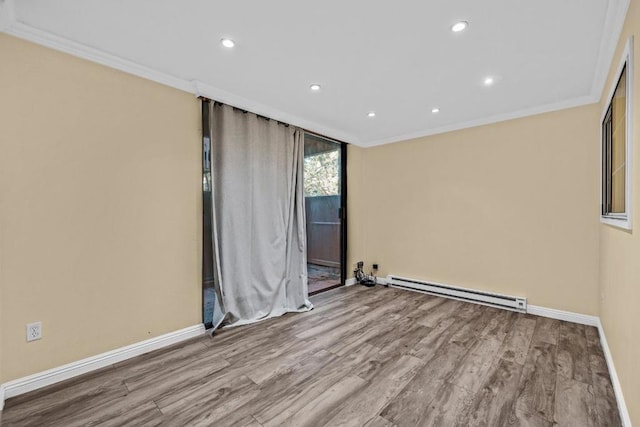 empty room featuring ornamental molding, a baseboard heating unit, and light wood-type flooring