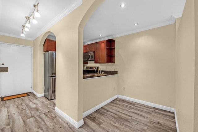 kitchen featuring sink, crown molding, light wood-type flooring, and appliances with stainless steel finishes