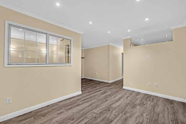 empty room featuring ornamental molding and hardwood / wood-style floors