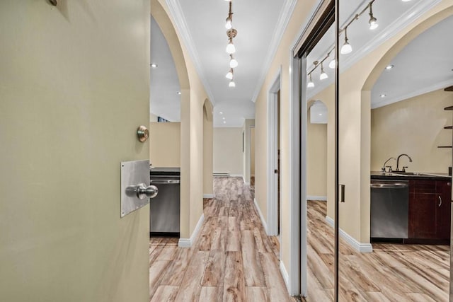 hall featuring crown molding, baseboard heating, sink, and light wood-type flooring