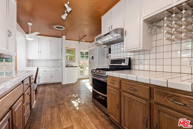 kitchen featuring range with two ovens, wood-type flooring, tile counters, and white cabinets