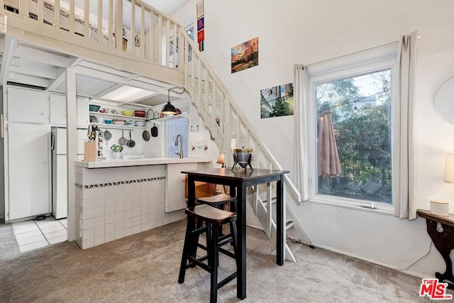 bar featuring light colored carpet and white cabinets